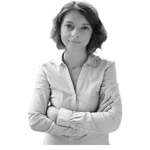 Client Anne ABOT, who is a woman with short hair, with her arms crossed and looking straight ahead.