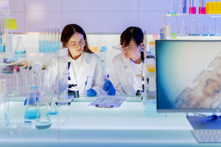 Deux femmes vérifient les résultats sur un banc de laboratoire.