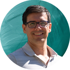 Notre collaborateur Julien Courtes avec les bras croisés, qui est un homme blanc avec des lunettes, cheveux foncés sans barbe.